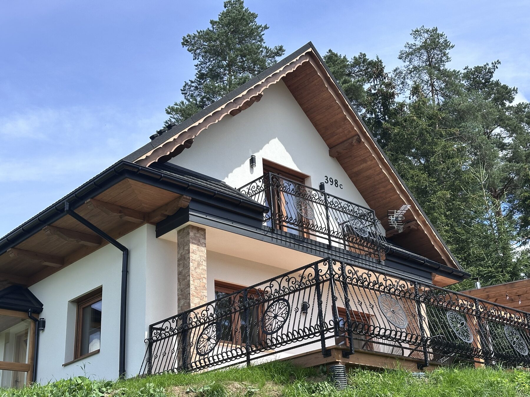 Front domku z balkonem i kutą balustradą