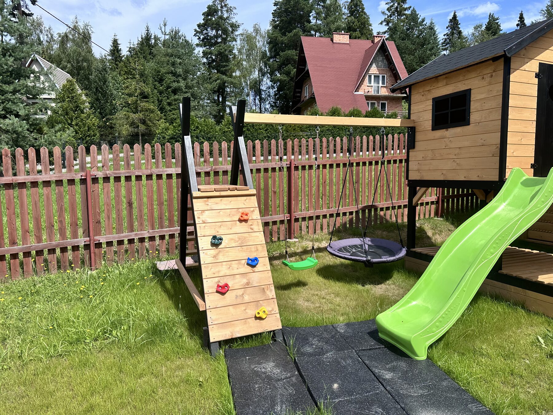Plac zabaw z domkiem, zjeżdżalnią i huśtawkami